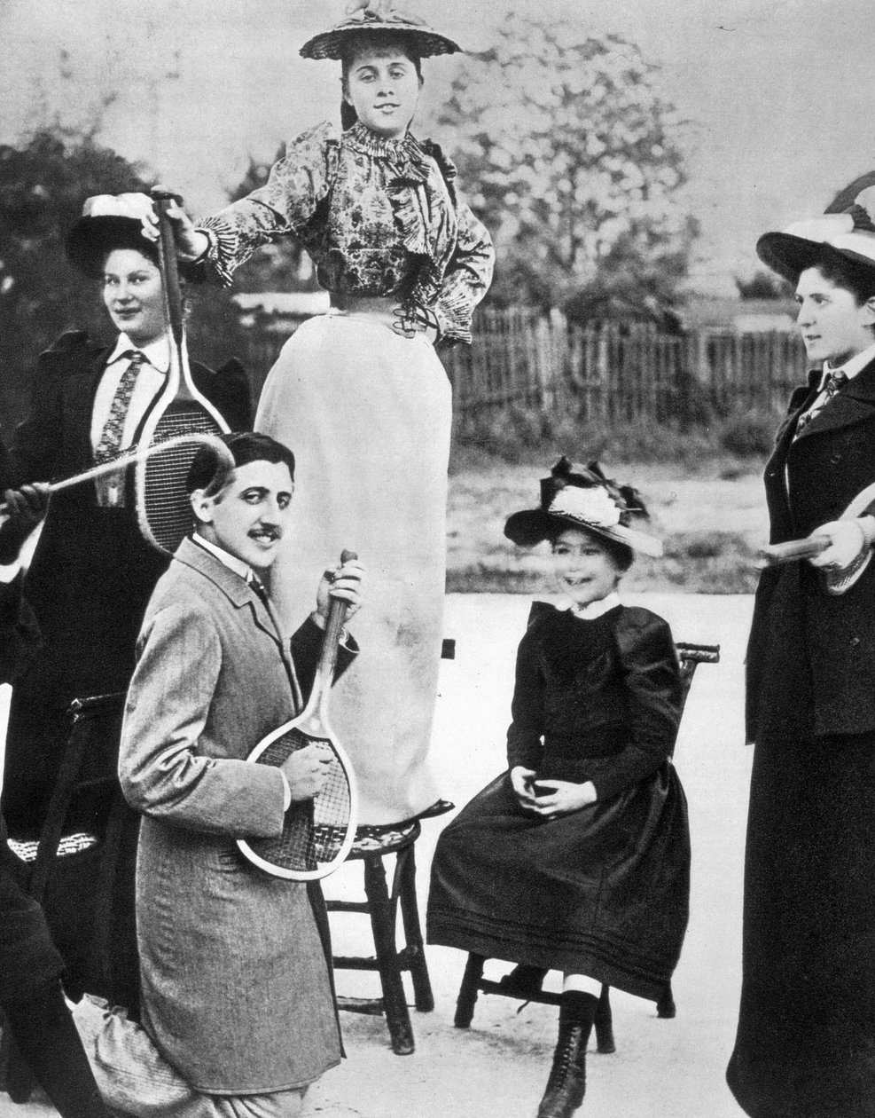 Marcel Proust, mitt i en grupp unga kvinnor, spelar gitarr på en tennisracket på Bineau Boulevard i Paris av Unknown photographer
