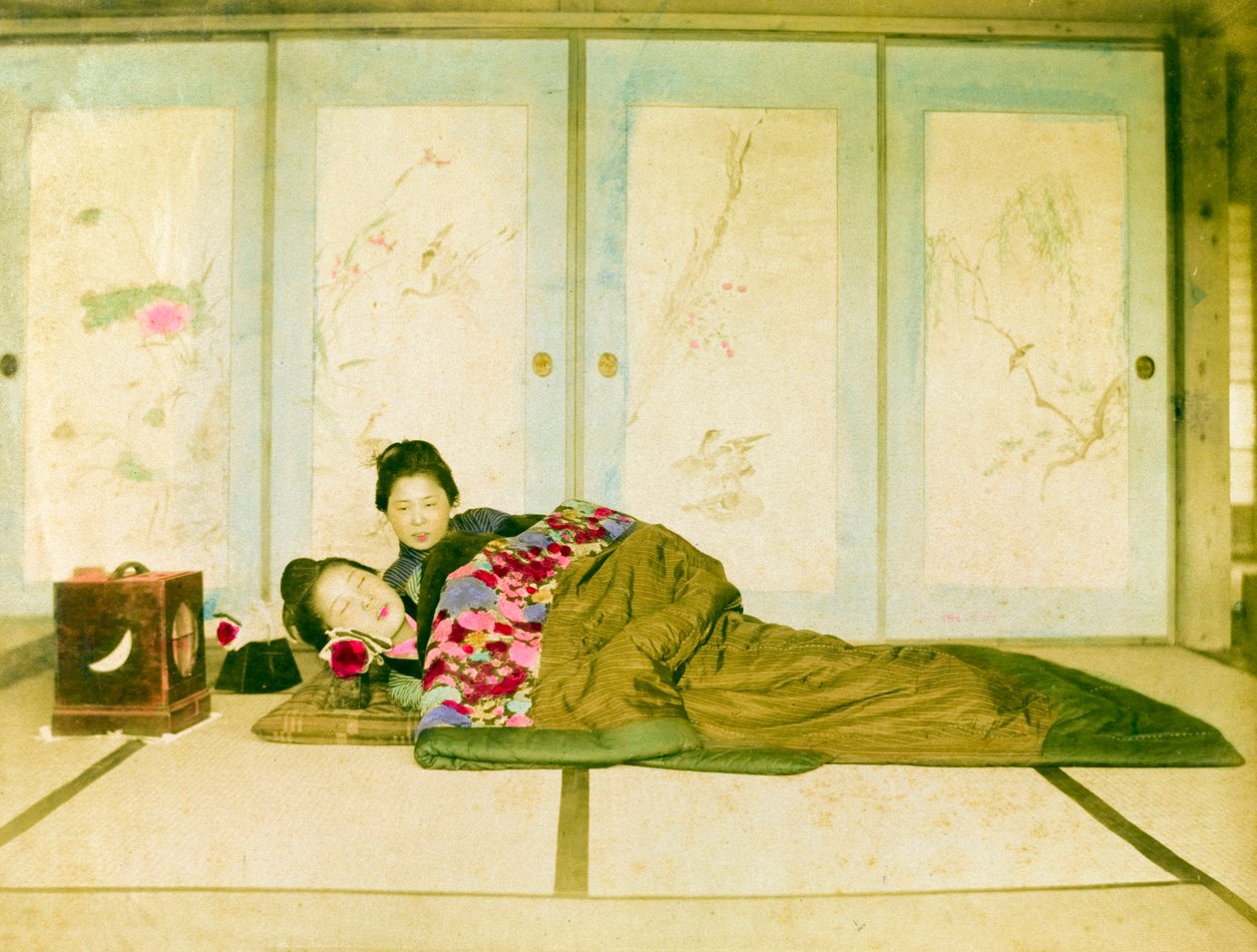 Liggande på en futon. Två japanska kvinnor ligger på en traditionell futon som är placerad på golvet. Japan, cirka 1910. Japan, Östra Asien, Asien. ©Cultural Heritage Images/UIG/Leemage av Unknown photographer