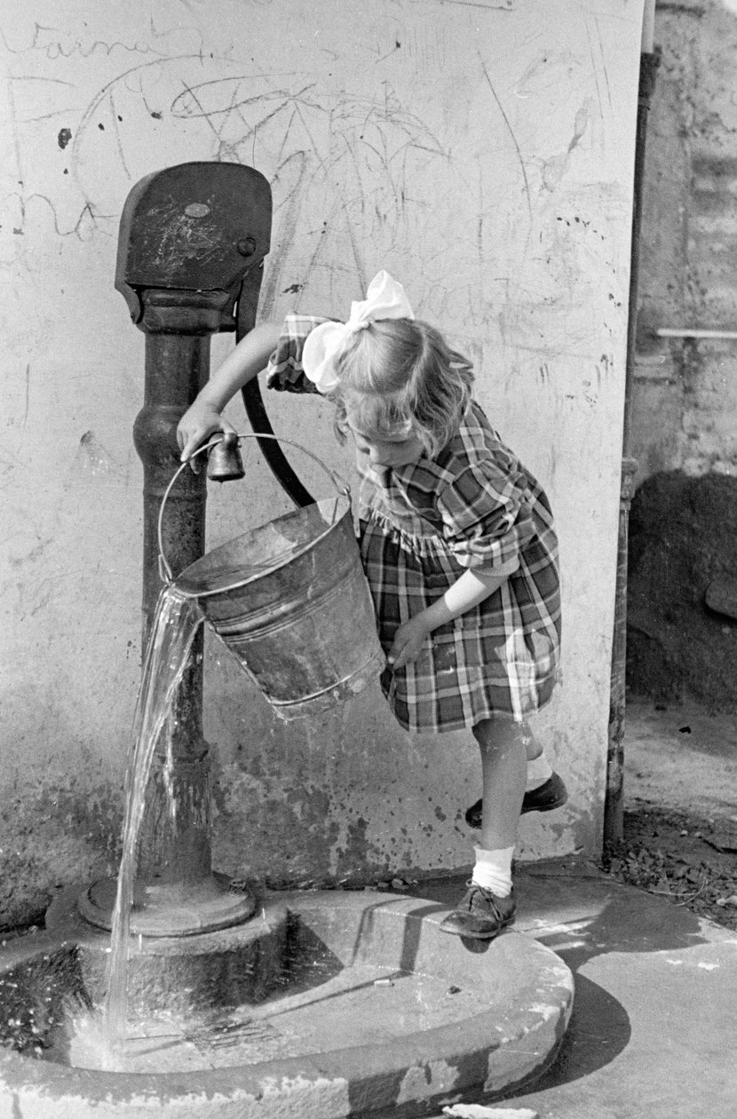 Liten flicka tömmer en hink med vatten i en pumpfontän, 9 maj 1939 (svartvitt foto) av Vincenzo Balocchi