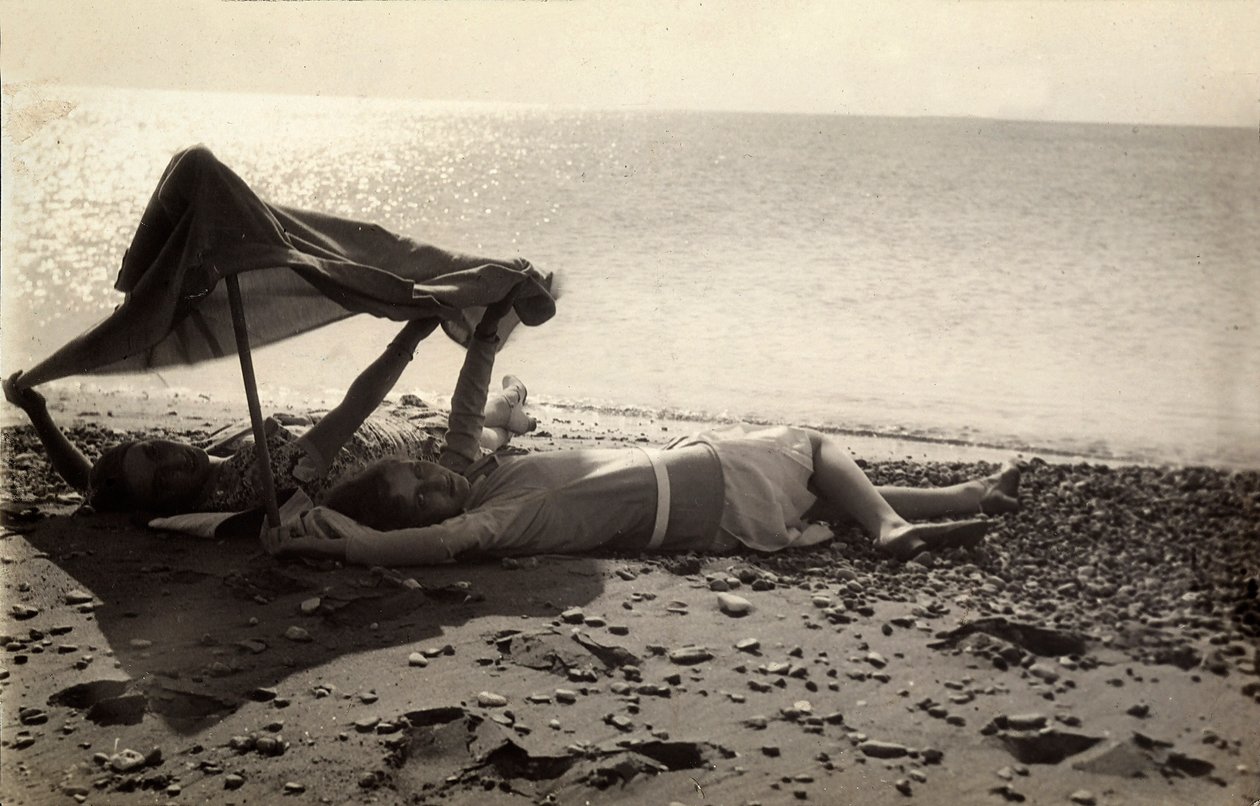 Två kvinnor ligger på stranden i skuggan av en handduk. Vykort skickat av fotografen till Vincenzo Balocchi av Vincenzo Balocchi