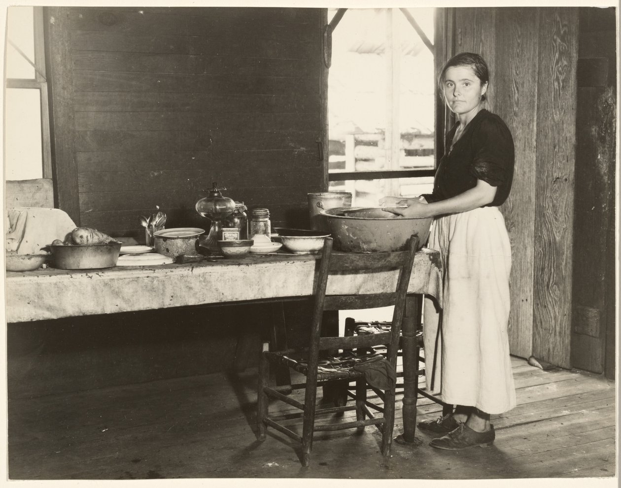 [Elizabeth Tengle vid köksbordet]/[Paralee Ricketts arbetar i köket] av Walker Evans