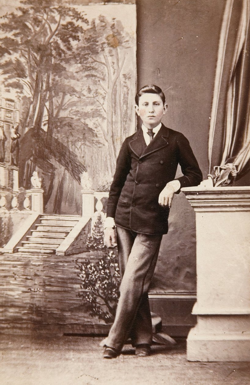 Studioporträtt av ung man framför målad bakgrund av trappor och trädgård av William Bentley