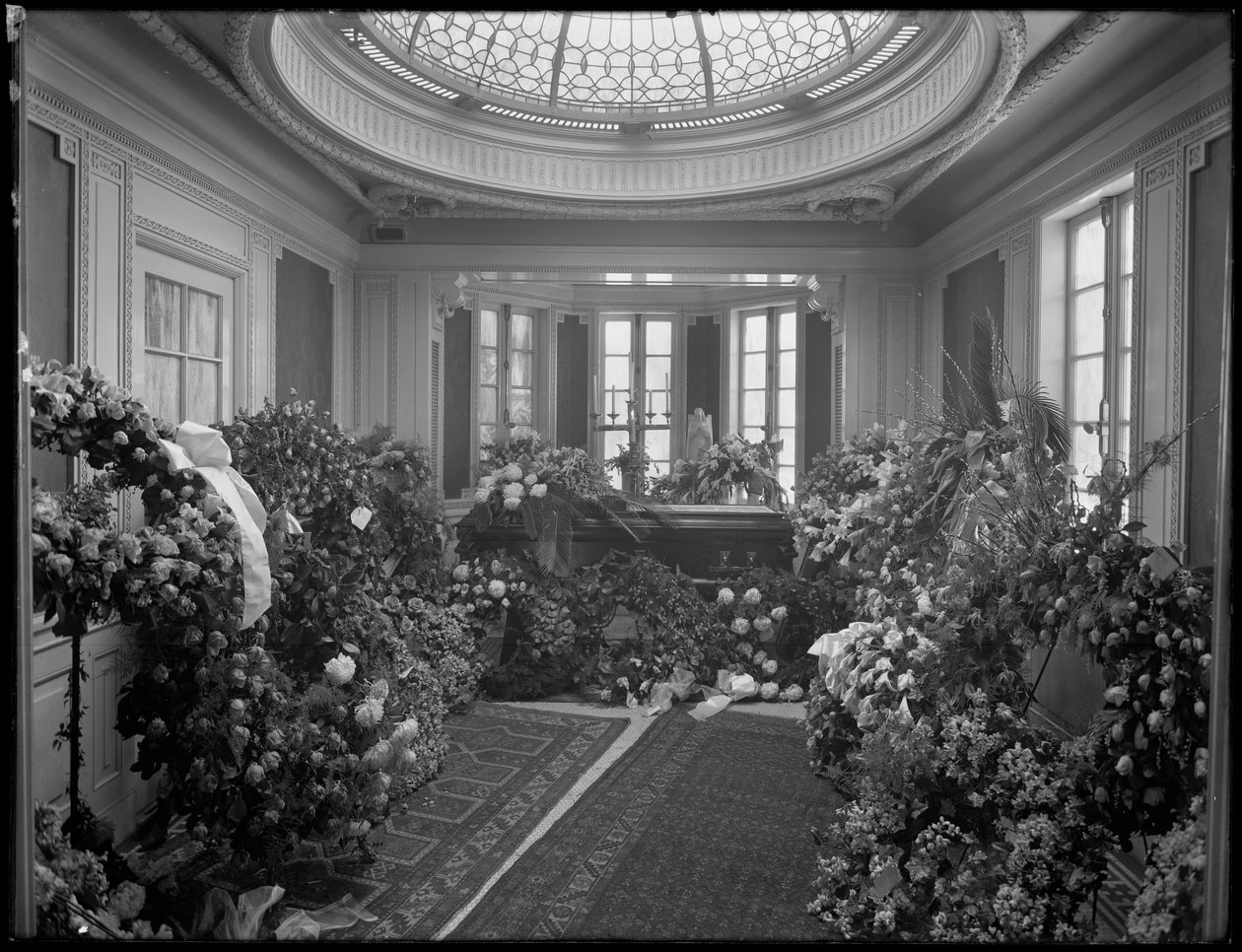 Oidentifierad begravningskapellinredning med kista och blommor, dekorerad för Octavio Davis, troligen James E. McLarney, undetaker, på 874 Lexington Avenue, New York City, 10 december 1915. av William Davis Hassler