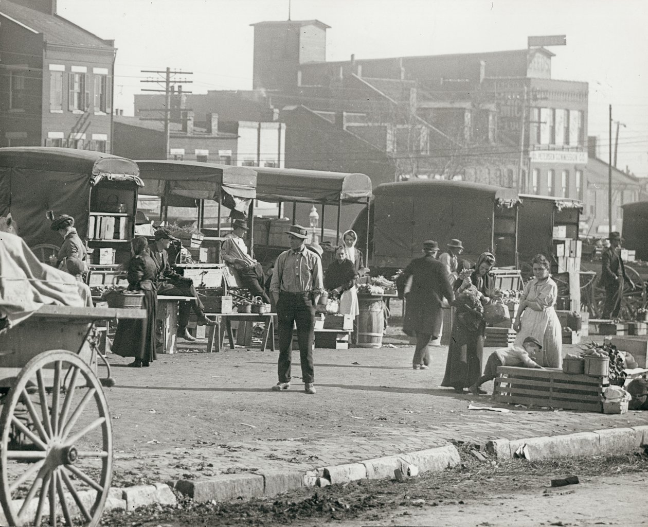 Horizontal, black and white photograph of market stalls and people shopping av William G. Swekosky