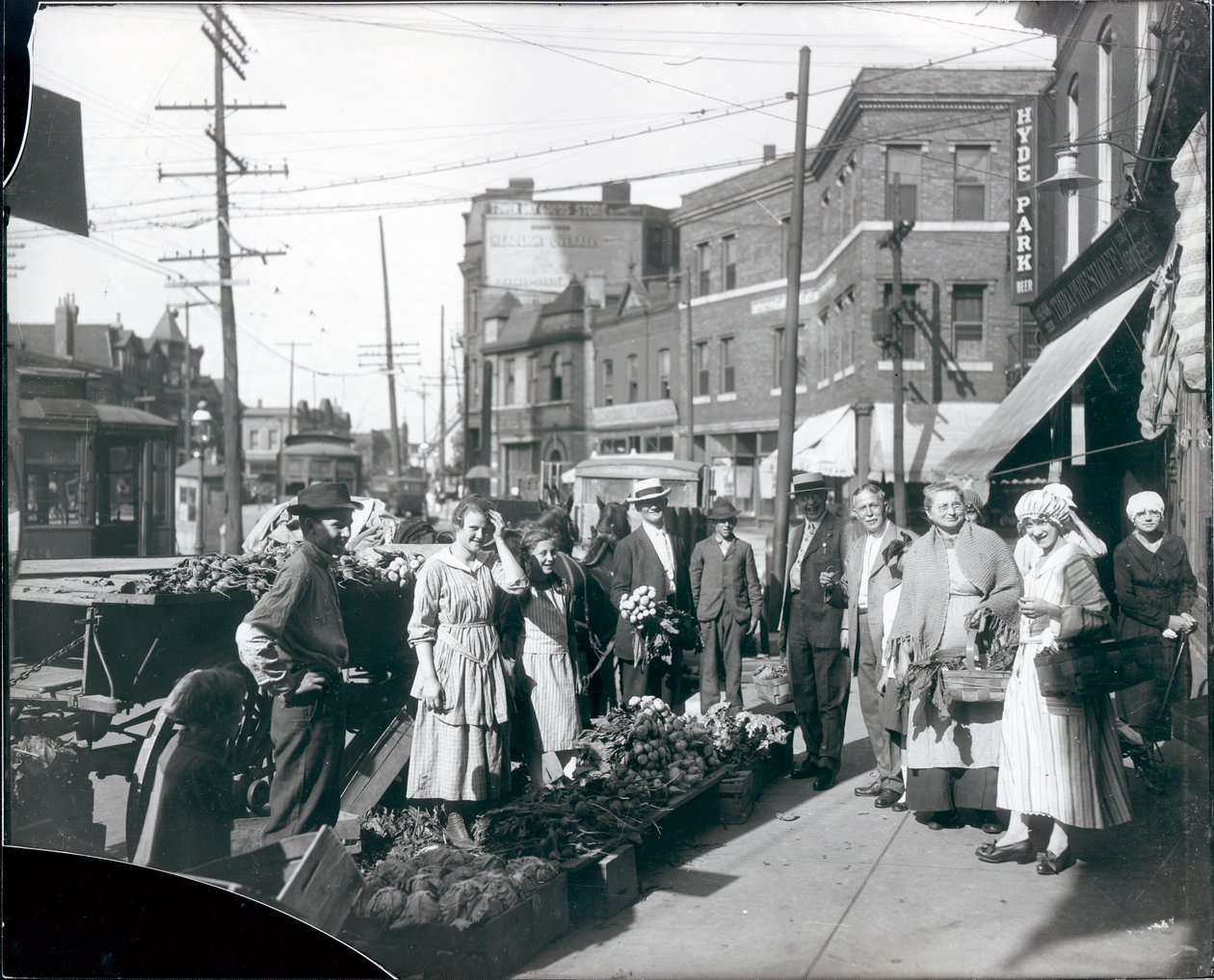 Shoppers gathered by sidewalk produce outside the Theodore Prieshoff Grocery, 1929 East Grand Avenue, near the Grand Avenue water tower av William G. Swekosky