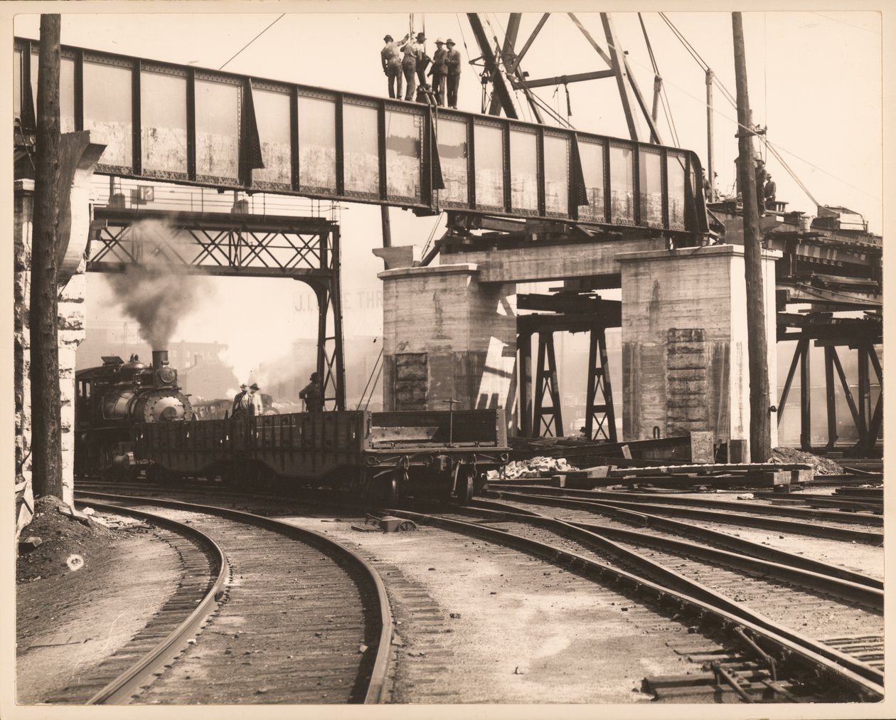 Workers standing on trestle as train passes underneath in unidentified train yard av William G. Swekosky