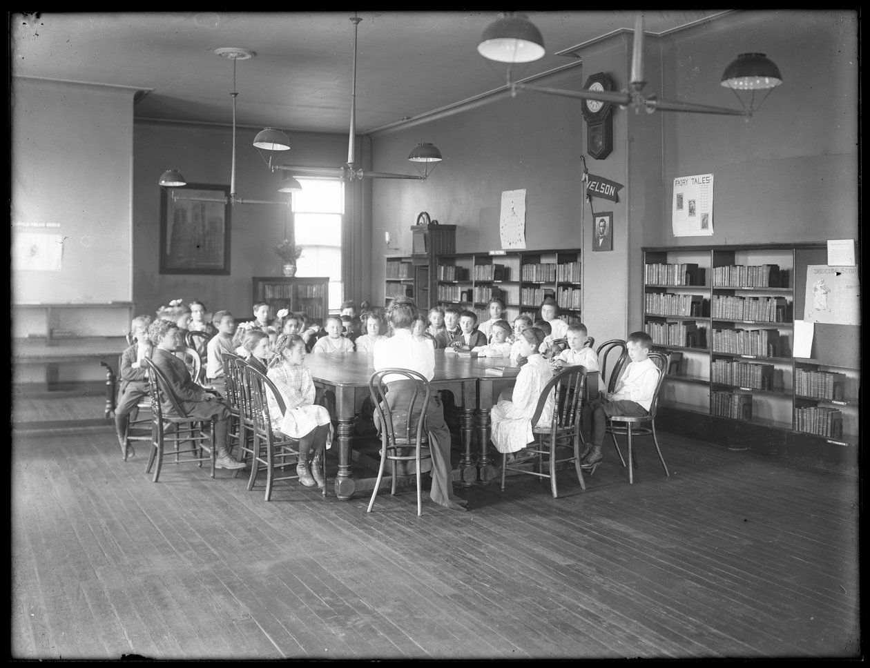 Barn lyssnar på en kvinna i läsesalen i en oidentifierad filial av Queens Borough Public Library, ca 1910 av William Davis Hassler