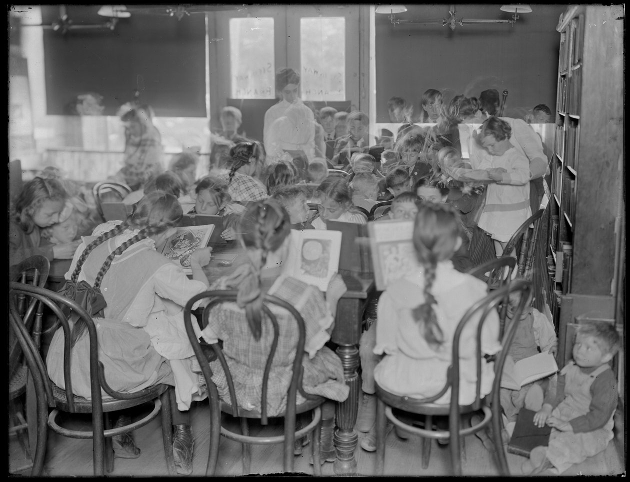Barn läser i läsrummet på en oidentifierad filial av Queens Borough Public Library, omkring 1910. av William Davis Hassler
