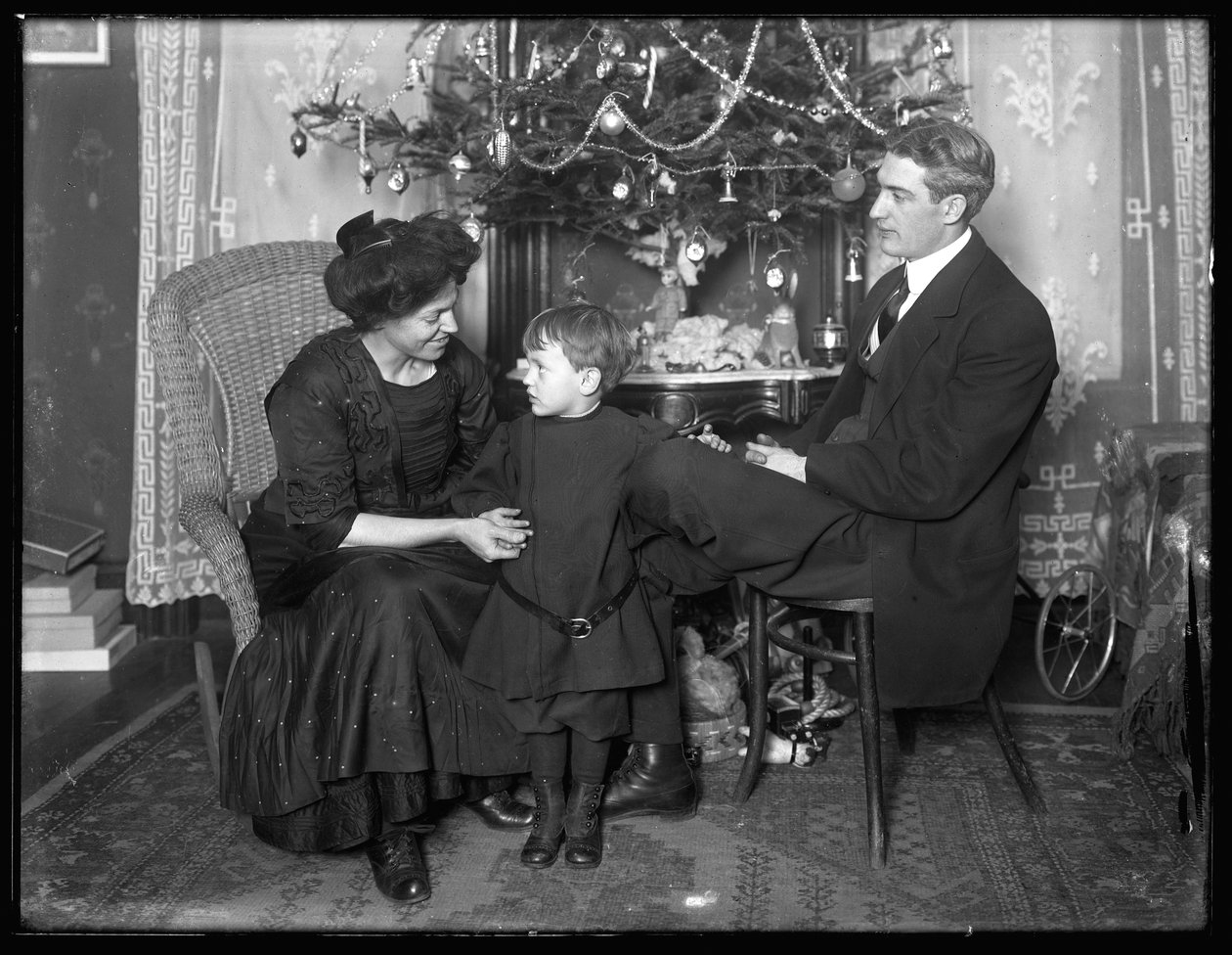Dan Seymour och familj i informell pose, sittande under en julgran, julen 1912 av William Davis Hassler