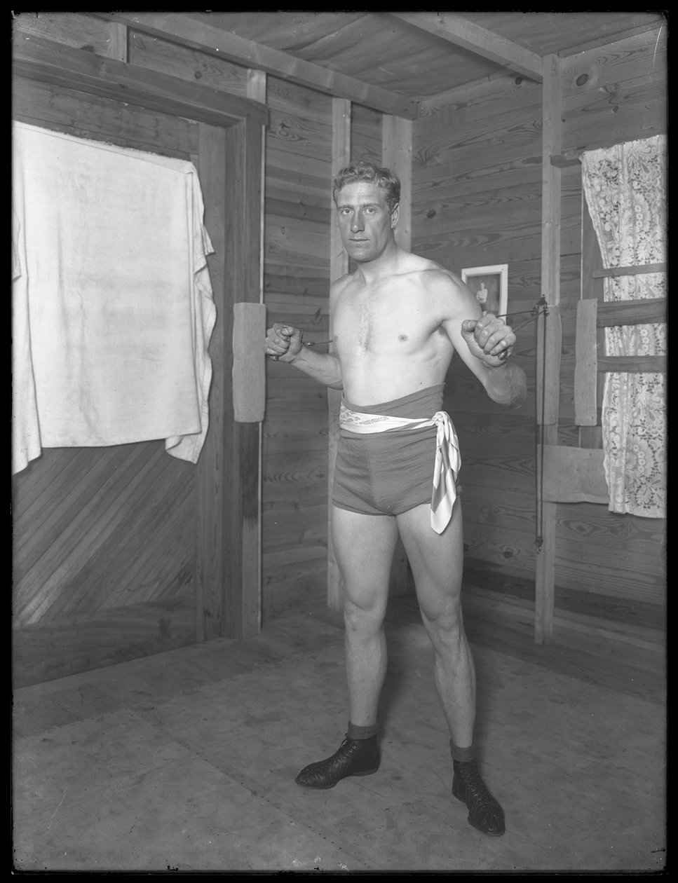 Engelske boxaren William Thomas Wells (Bombardier Billy Wells), poserar i träningsbyxor med viktremskivor, ca 1911 av William Davis Hassler