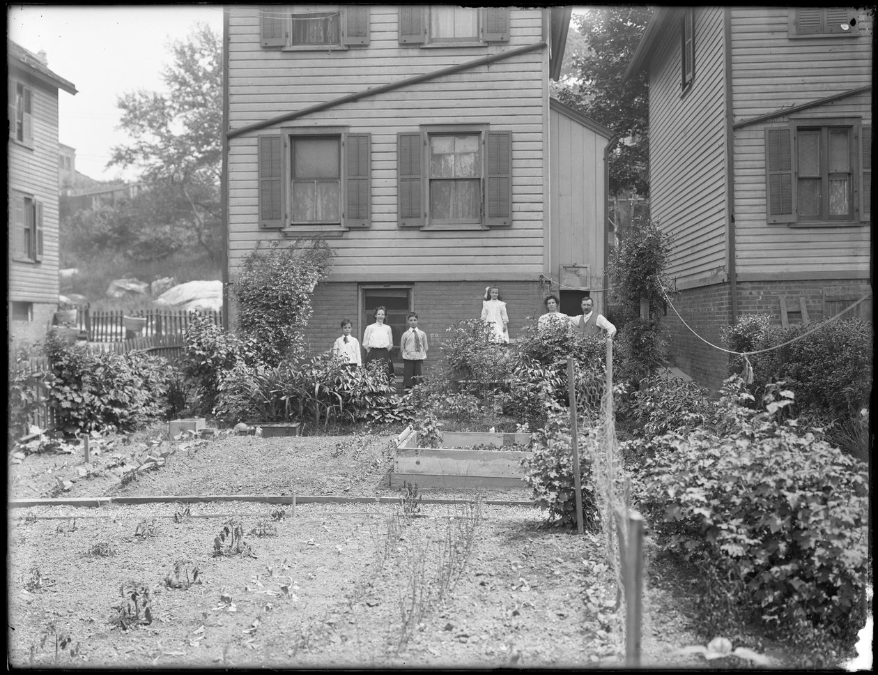 Familjen poserar bredvid sin grönsaksträdgård på bakgården, Inwood, New York, ca 1910 av William Davis Hassler