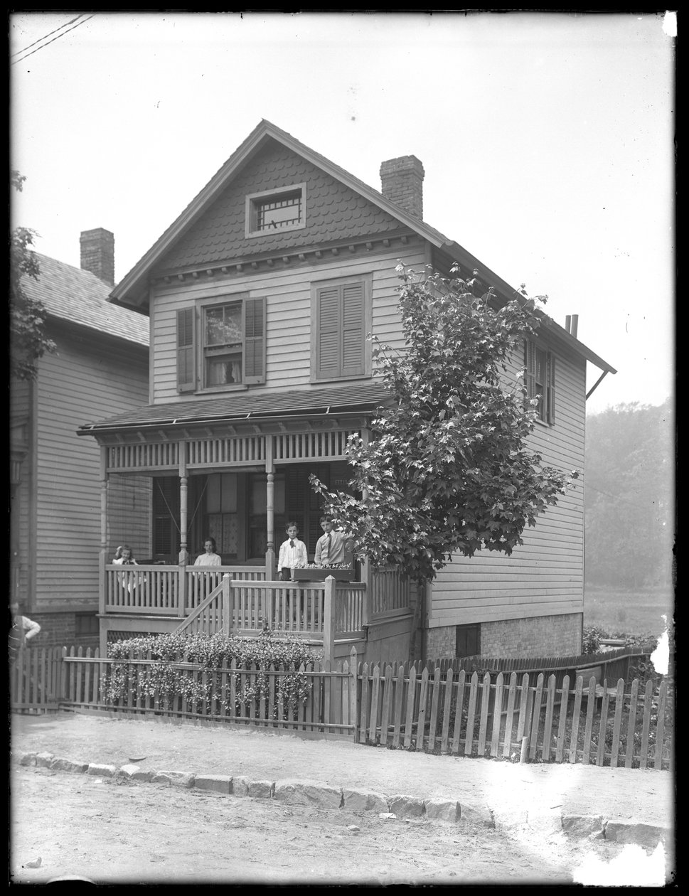Fyra barn poserar på verandan till ett hus vid en flod eller sjö, Inwood, New York, ca 1910. av William Davis Hassler