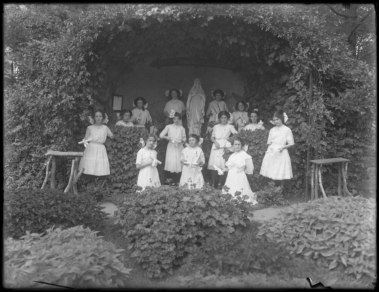 Avgångsklass av flickor från den romersk-katolska föräldralösa asylen poserade framför grottan med sina diplom, 1912 av William Davis Hassler