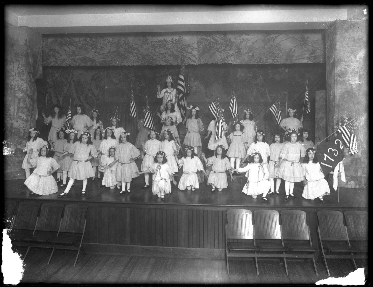 Gruppporträtt av småflickor under en föreställning, troligen på det romersk-katolska barnhemmet, Kingsbridge, Bronx, omkring 1911. av William Davis Hassler