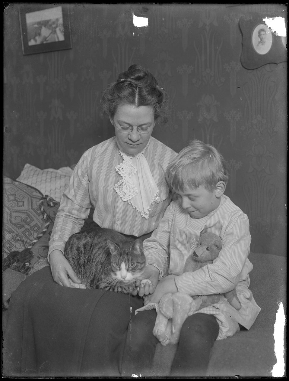 Harriet E. Hassler och William Gray Hassler, sittande med tabbykatt (Reddy) och nallebjörn, ca 1911 av William Davis Hassler