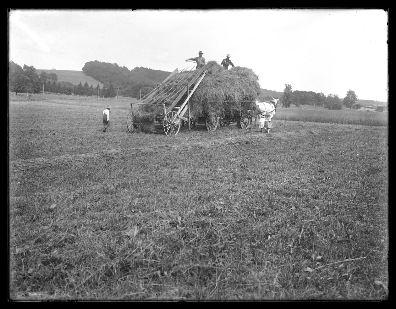 Hövagn, lantarbetare och barn, visar apparater för att lyfta höet, McCready Farm, Crawford County, Pennsylvania, ca 1913 av William Davis Hassler