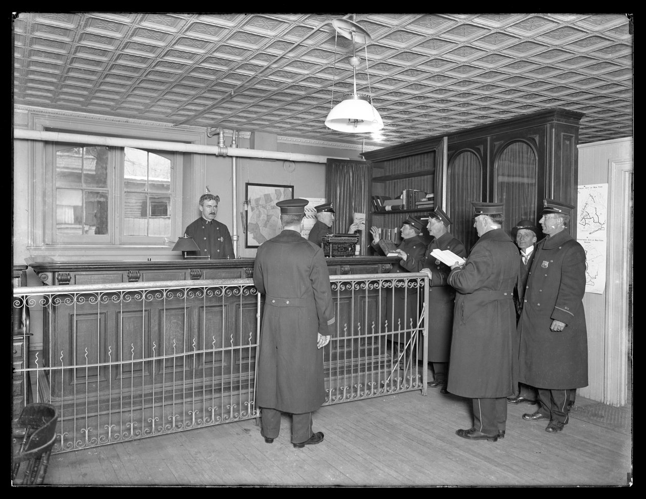 Interiör av oidentifierad polisstation, visar officerare och reception, ca 1913-14 av William Davis Hassler