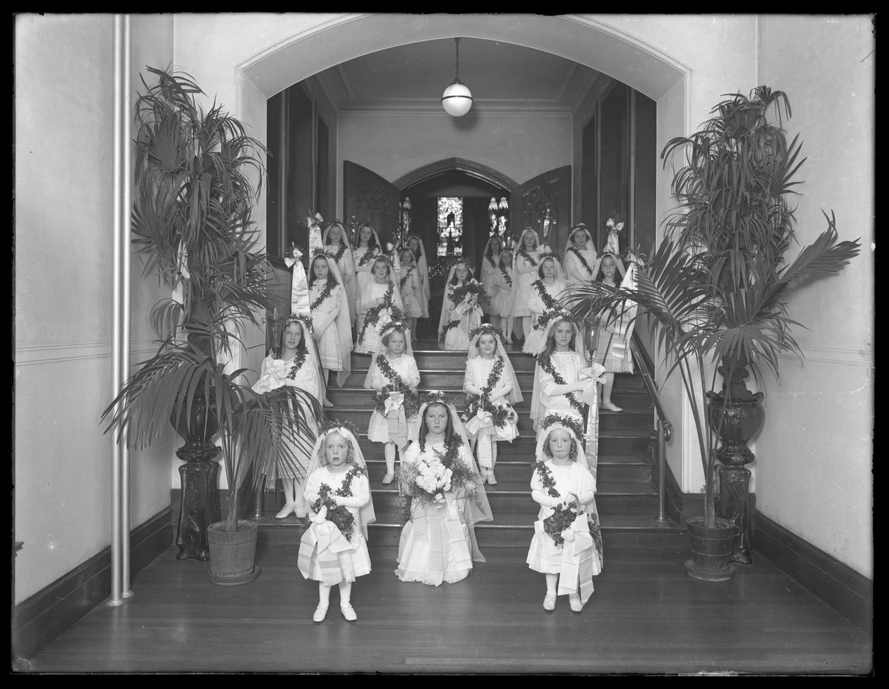 Små flickor på The Roman Catholic Orphan Asylum, Kingsbridge, Bronx, kommer tillbaka från kapellet i vita klänningar med kransar och girlanger, 20 oktober 1914 av William Davis Hassler