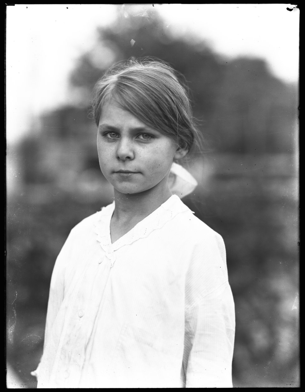 Utomhusporträtt av en oidentifierad liten flicka i en vit klänning, juli 1915 av William Davis Hassler