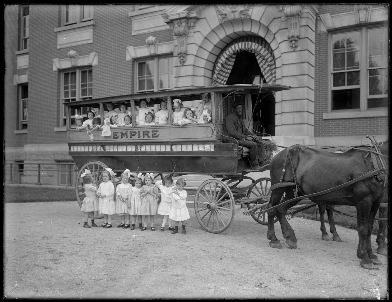 Små flickor poserar i och framför en hästdragen vagn, framför en oidentifierad byggnad, troligen det romersk-katolska föräldrahemmet, Kingsbridge, Bronx, ca 1910 av William Davis Hassler