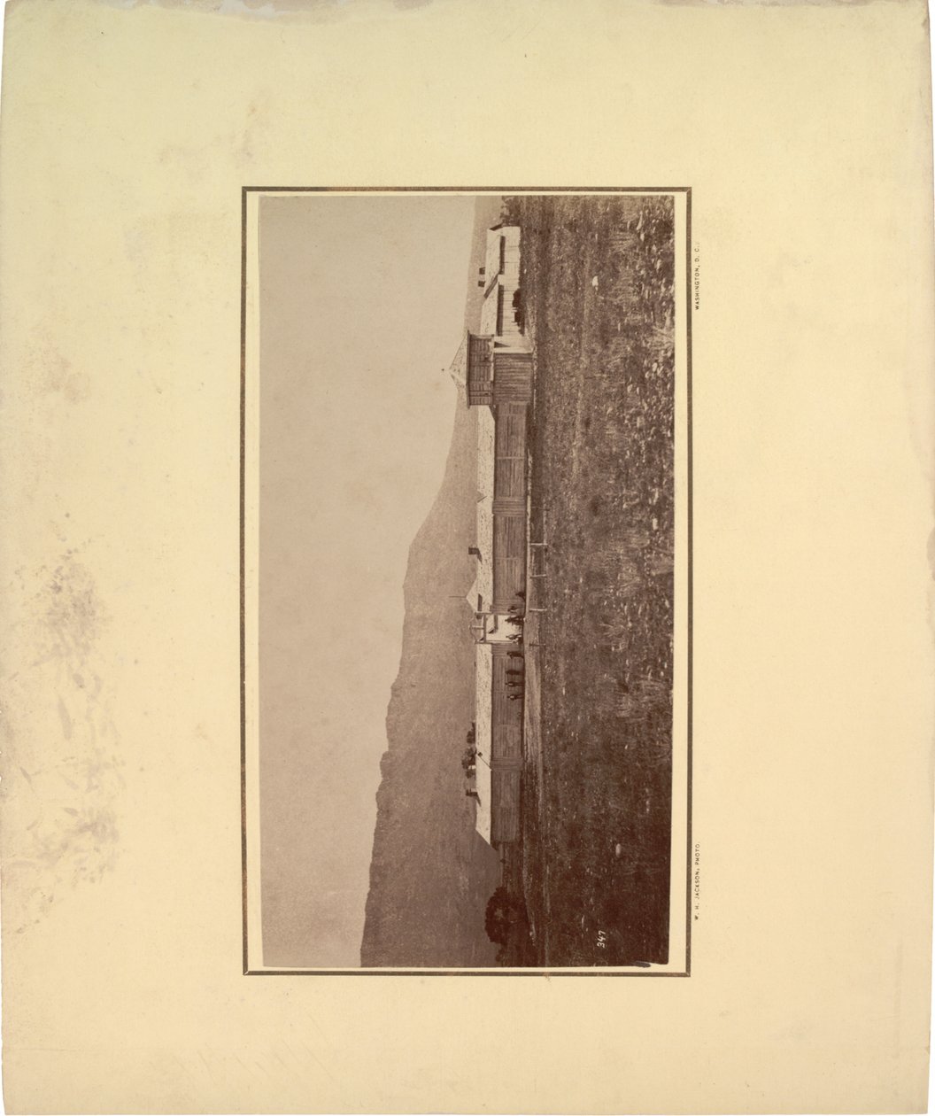 Utsikt över en stockade med flera män samlade vid ingångsporten, 1871 (sepiafoto) av William Hicks Jackson