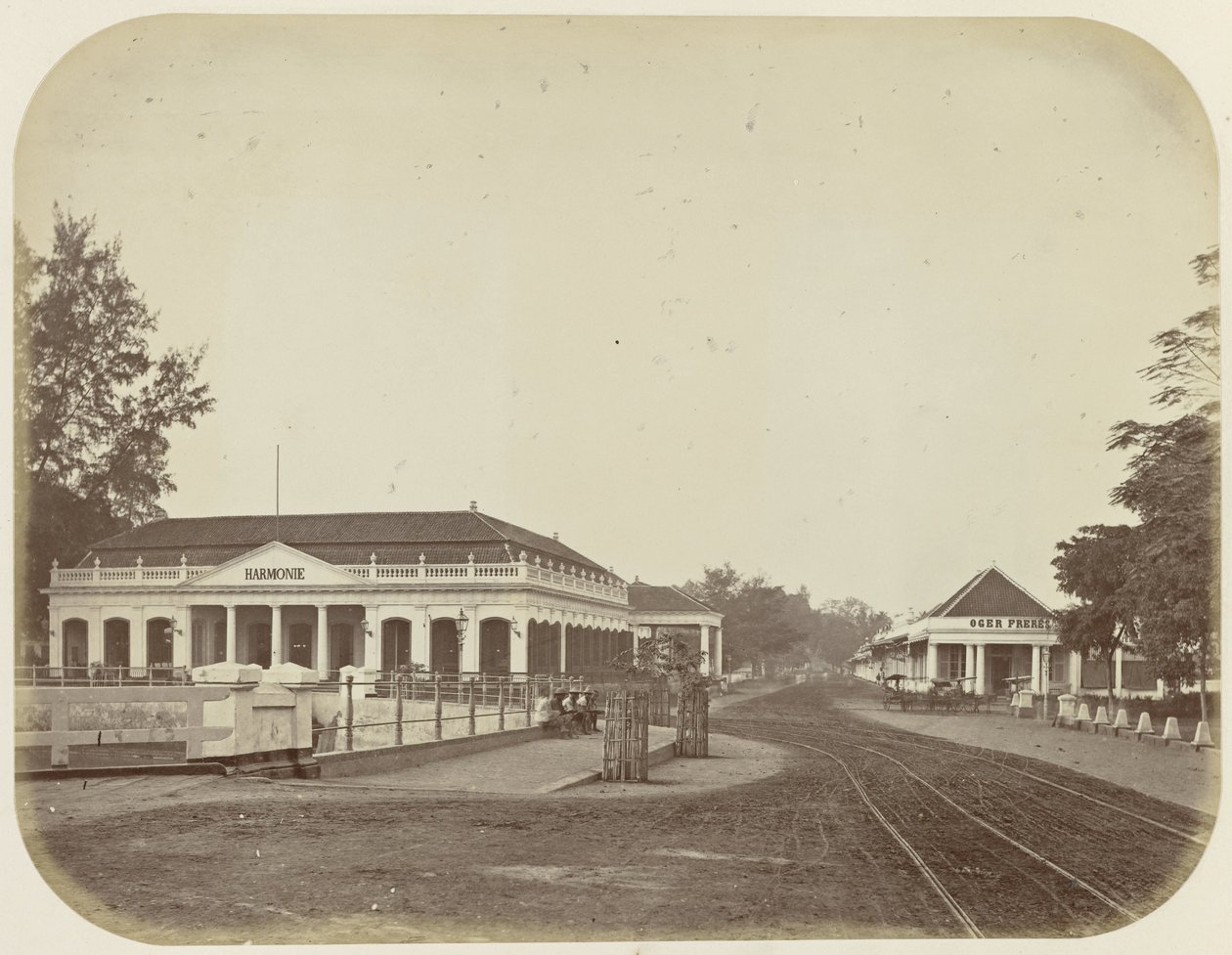 Sociëteit Harmonie och Oger Frères butik i Batavia av Woodbury and Page