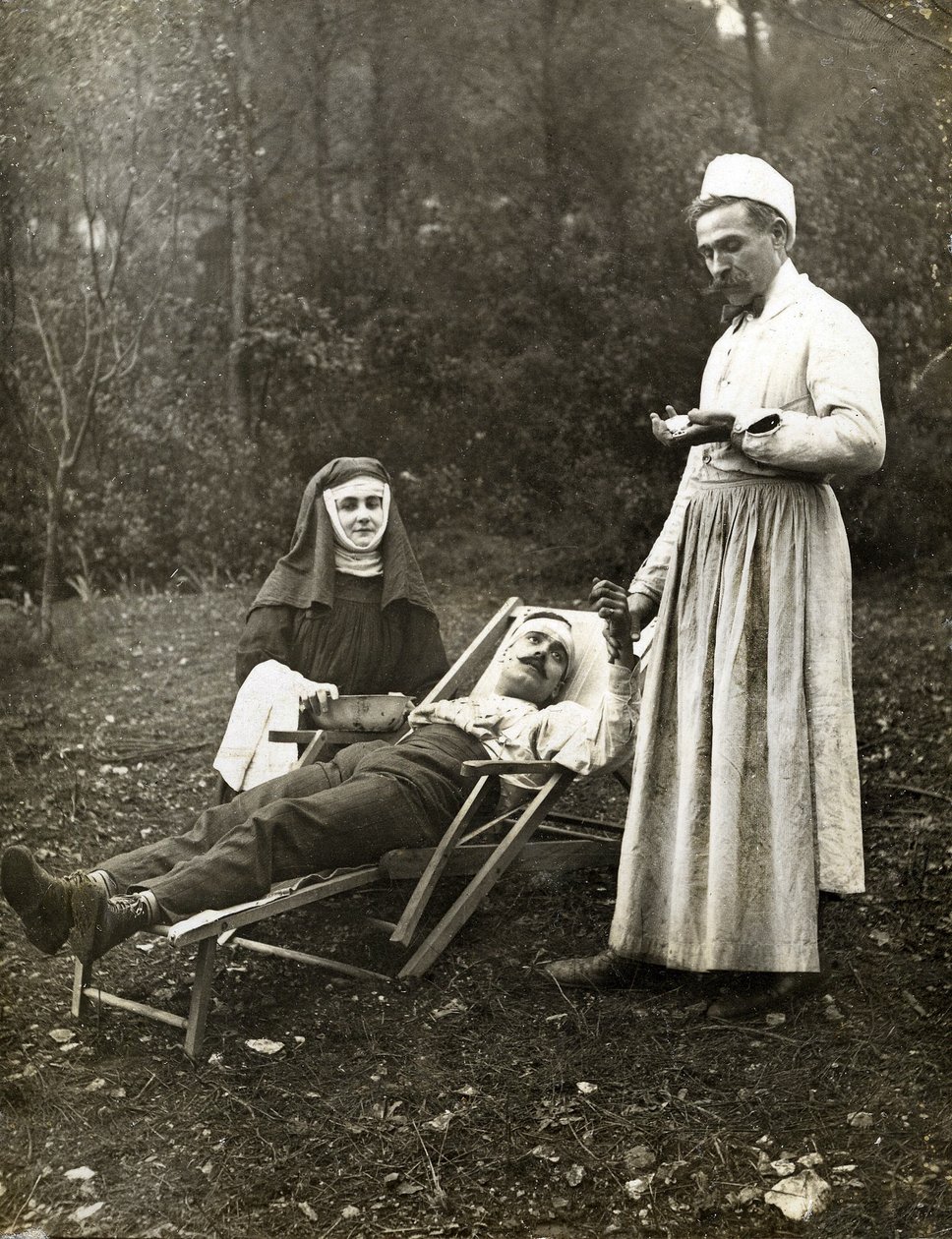 Läkare tar pulsen på en skadad man, assisterad av en nunna, cirka 1900 (s/v foto) av . .