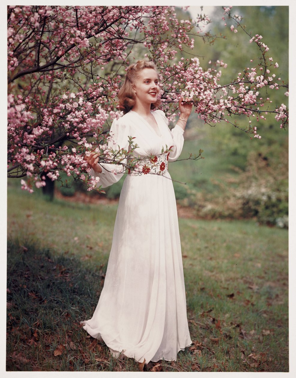 Kvinna som modellerar en klänning nära blomningen, ca 1940-talet av Frederick (attr. to) Barnard