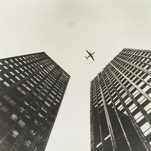 Flygplan som flyger över två torn, fotografi med  svart, väggkonsttryck på begäran av F. Abderrahim