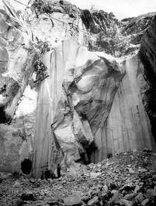 Grävmaskiner i arbete längs en brant vägg i ett marmorbrott i Apuan Alps, Toscana. (s/v bild)
