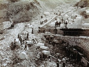 Järnvägsstation med arbetare som lastar marmorblock på järnvägsvagnar, tre par oxar med transportvagnar är synliga (s/v foto) av Fratelli Alinari