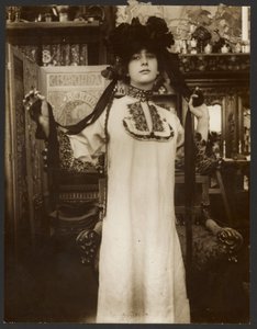 [Kvinnlig modell i lång vit dräkt och hatt med band, Paris] av Alphonse Maria Mucha