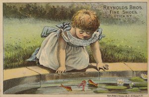 Ung flicka tittar på fisk i damm av American School