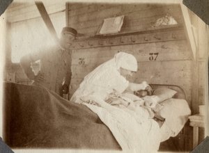 Första världskriget 1914-1918: sjuksköterska i blus rakar en soldat (franska krigssår ligger i en säng), i Couville, Manche, Basse-Normandie (Lagre Normandie), Frankrike. Anonymt fotografi juli 1917. Privat samling, Stella. av Anonymous Anonymous