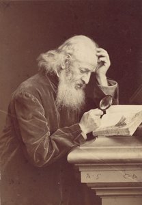 [Skäggig man med förstoringsglas undersöker ett manuskript], 1870-talet.