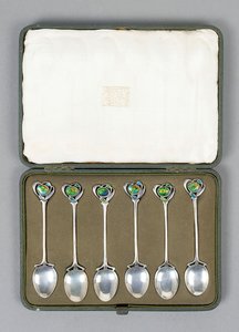 En förpackad uppsättning Cymric silverskedar med emaljerade ytterslut designade av Archibald Knox (1864-1933)