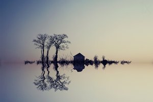 Lugnt vatten och dess spegelbild