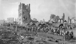 En oidentifierad australiensisk maskingevärsektion med packade hästar som passerar ruinerna av tyghallen. Notera flera motorbilar parkerade i bakgrunden, 19 oktober 1917 av Australian Photographer