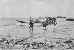 Australiska soldater som vadar genom vattnet när de kommer iland vid Anzac Cove, Gallipoli den 25 april 1915 efter att ha transporterats i landningsbåtar från större fartyg i bakgrunden, 25 april 1915 (
