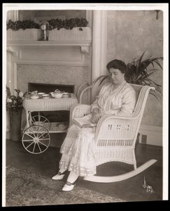 Mrs. Howard satt med en bok i en gungstol i sitt hem på 200, 5th Avenue, New York, 1915-6 (silvergelatintryck)