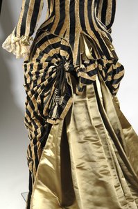 Aftonklänning, ca 1884 (baksidan sned vy av livliga detalj). Sidensatin och skuren sammet, spets, sidentråds tofsar och fransar. Charles Frederick Worth, Frankrike.