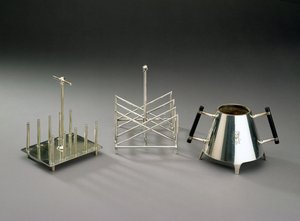 Toastställ med upprättstående stöd, tillverkat av Hukin & Heath, 1878 (se 46533 för detaljer); rostat brödställ med triangulär sektion, tillverkat av Elkington & Co., ca 1875-88; sockerskål med eboniserat trä h