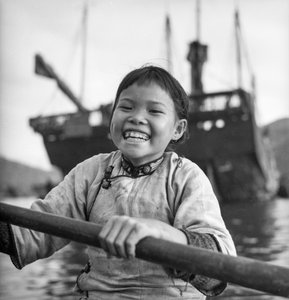 Ett porträtt av en ung flicka i en sampan i Aberdeens hamn, Hong Kong.