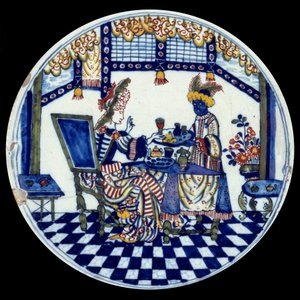Delft porslinstallrik som föreställer en kvinna vid ett bord som serveras av hennes svarta tjänare. 1705 Sevres, Nationalmuseum för keramik av Dutch School