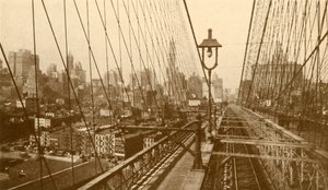 Lower Manhattan sett genom nätverket av kablar på Brooklyn Suspension Bridge, c1930. av ENA