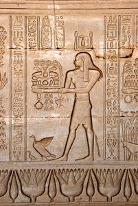 Egyptisk antikvitet: representation av en man som ger offer till gudinnan, Hathortemplet, Denderah, Egypten - egyptisk civilisation: en man som bär offergåvor till gudinnan Hathor, ristad på väggen av Hathortemplet (eller Tentyratemplet) i Denderah av Egyptian Ptolemaic Period