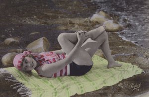 Flicka som ligger på handduken på stranden (färgat foto) av English Photographer