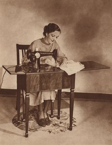 Hemmafru i arbete vid symaskinen, mitten av 1930-talet (svartvitt foto) av English Photographer