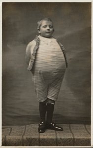 Skolpojke, utklädd för att ha en mycket stor mage (s/v foto) av English Photographer
