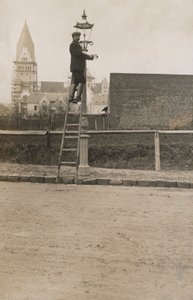 Man uppför en stege och fixar en gatlykta (s/v foto) av European Photographer